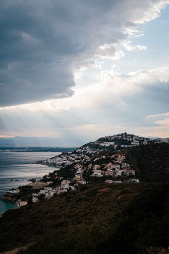 A vertical shot of a town on a hill on the island with a beautiful sea view under the sunlight