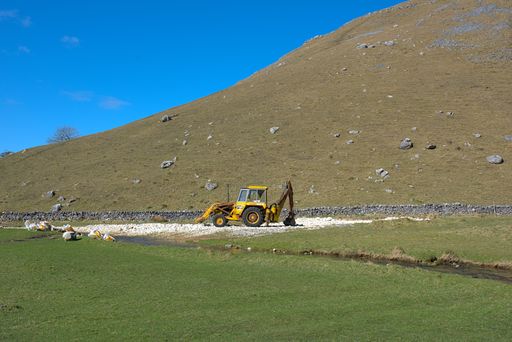 A closeup shot of an excavator working in the green field