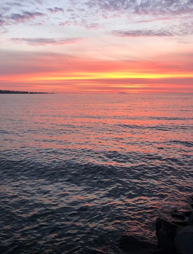 A vertical shot of a beautiful mesmerizing pink sunset over the sea in Reykjavik, Iceland