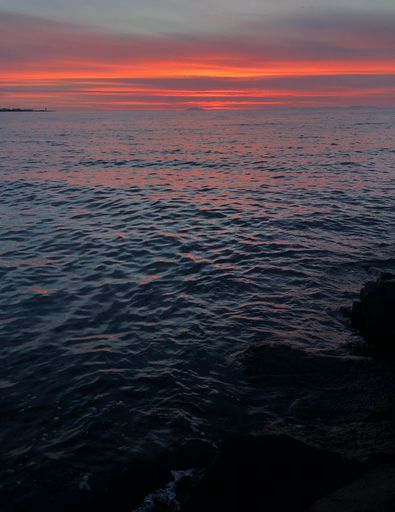 A vertical shot of a beautiful mesmerizing pink sunset over the sea in Reykjavik, Iceland