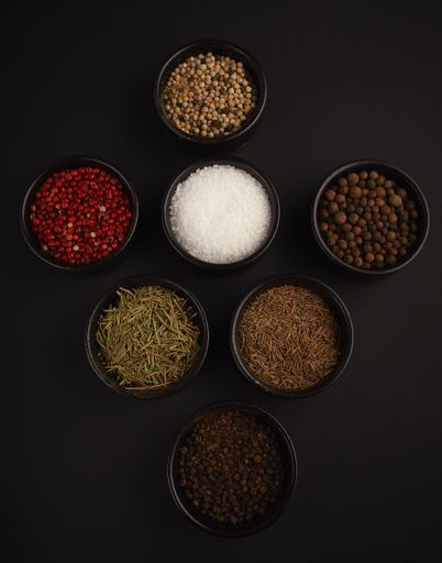 Different types of cooking ingredients aligned on a black background