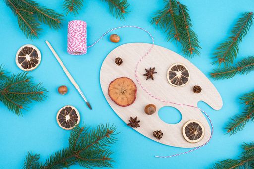 Christmas decoration on a blue colored background, branches of fir, dry oranges and apples