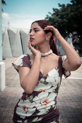 A vertical shot of a redhead attractive young Hispanic female posing in a sexy dress
