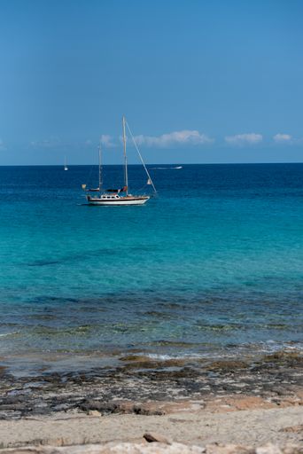A boat moored on the coast of Ses Illetes beach in Formentera, the Balearic Islands in Spain