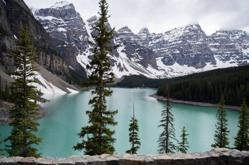 A landscape of Moraine Lake surrounded by rocky hills covered in the snow in Canada