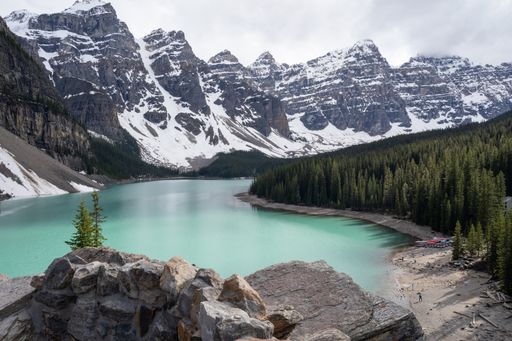 A landscape of Moraine Lake surrounded by rocky hills covered in the snow in Canada