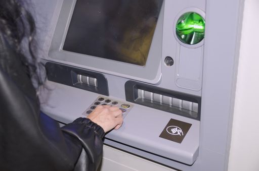 A person using an ATM machine to take out money from her credit card