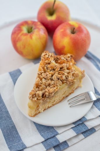 A vertical shot of a slice of apple cinnamon pie with oatmeal on a plate on the table