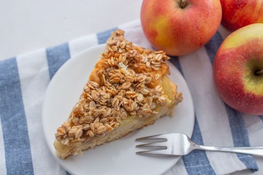 A closeup of a slice of apple cinnamon pie with oatmeal on a plate on the table