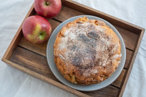 A top view of a delicious apple pie with sugar powder on a plate on a tray