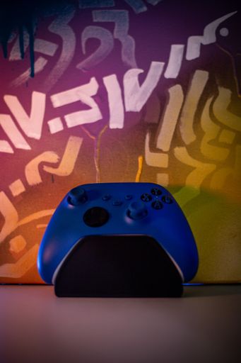 A vertical shot of a video console controlled on a painted art background