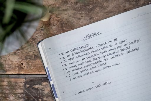 A closeup shot of an opened textbook with mantras written in it - suitable for every person
