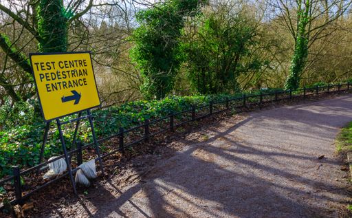 A yellow sign of a test center for pedestrians in the park