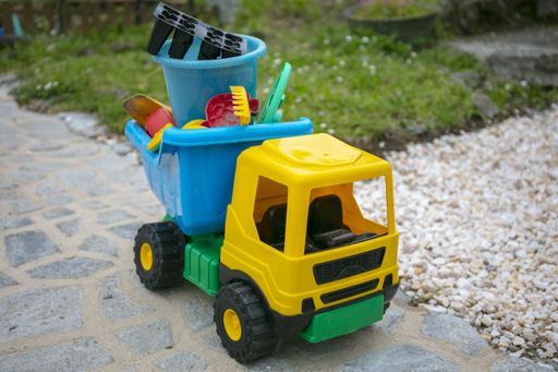 A yellow toy truck in the yard