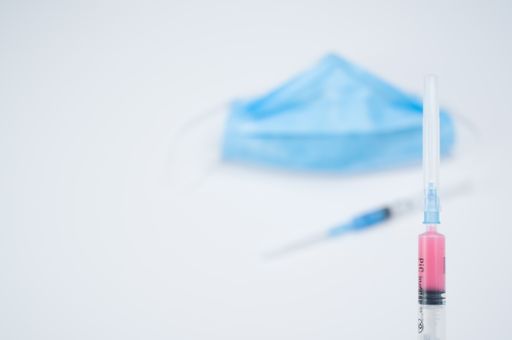 Isolated respiratory mask with syringe on a white background with text space