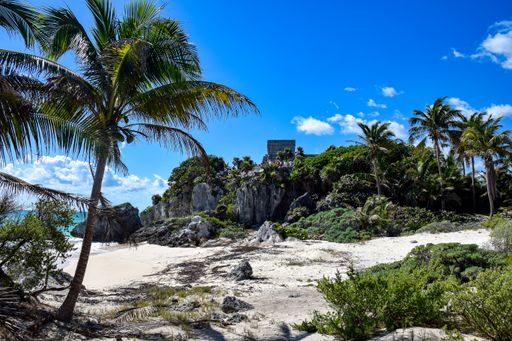 A beautiful view of the rocky sandy beach under the cloudy blue sky