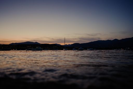 The beautiful Lake Garda with boats under a blue cloudy sky during the sunset