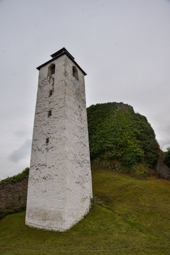 A vertical low angle shot of a tower in a forest during the day