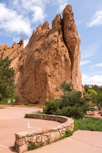 Majestic rock formations at Garden of the Gods, Colorado Springs, under a clear blue sky with lush greenery and pathways.