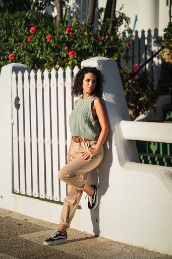 A vertical shot of a Spanish female posing in the street