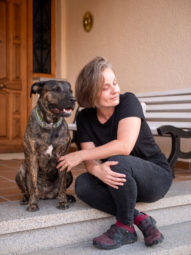 A vertical shot of a Hispanic female with her dog