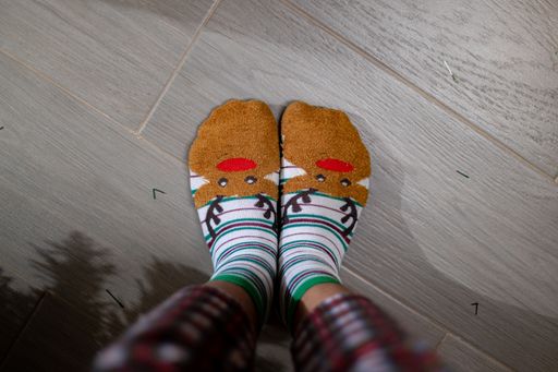 A top view child's feet with colorful socks with deers. The Merry Christmas concept