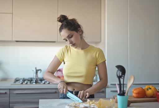 A shallow focus shot of a young female cooking in the kitchen