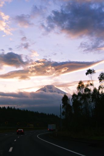 A vertical shot of a road and a beautiful cloudscape in the background.