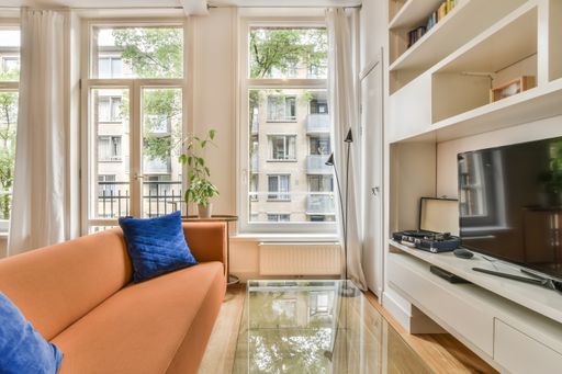 A beautiful image of a living room area with floor-to-ceiling windows in a white interior design house