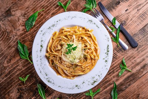 A top view of a cheesy pasta on a white plate