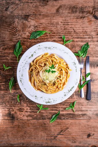 A top view of a cheesy pasta on a white plate