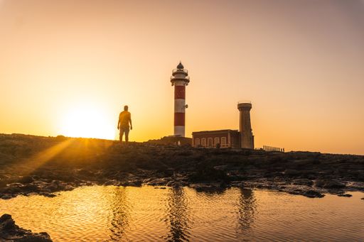 A silhouette of a male standing near the Toston Lighthouse in Punta Ballena, Fuerteventura, Canary Islands, Spain