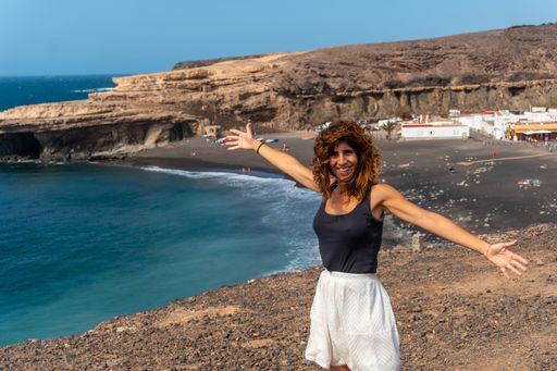 A causacian female happily posing on the beach of Ajuy, Pajara, west coast of the island Fuerteventura, Canary Islands, Spain