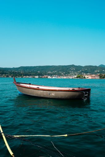A vertical shot of a boat in Lake Garda. Salo, Italy