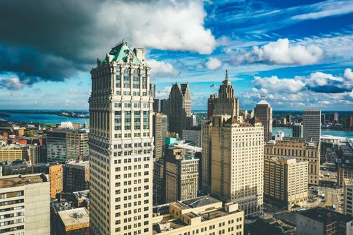 A cityscape of Detroit under the sunlight and a dark cloudy sky at daytime in Michigan in the US