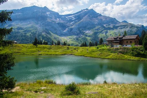 A beautiful view of the Lake Retaud surrounded by the Alps under the cloudy blue sky