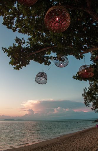 A vertical shot of a sandy seashore under a sunset sky