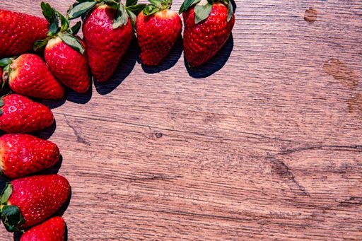A bunch of fresh red strawberries drying on a wooden surface with copy space
