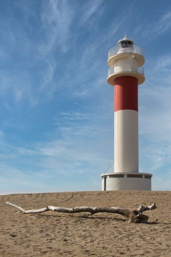A vertical shot of the Far del Fangar lighthouse in Ebro Delta, Spain on a sunny, cloudy day