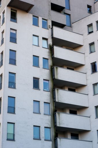 A vertical shot of a modern apartment building with balconies in the Piastowskie district