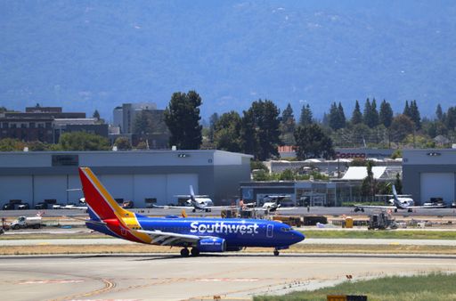 Southwest Airlines Boeing 737-700 lands at San Jose airport with Santa Cruz mountains in the background.