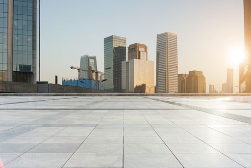 empty concrete ground floor with modern cityscape and buildings during sunset.