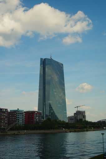 The European Central Bank at Osthafen Frankfurt in the light of the evening sun against a blue sky with clouds.