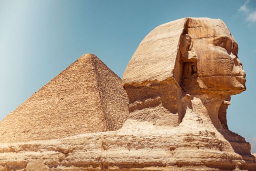 The Great Sphinx and Pyramid of Giza under a clear blue sky in Egypt.
