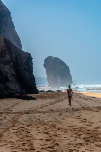 A vertical shot of woman on the Roque Del Moro in Cofete beach, Jandia natural park, Barlovento, south of Fuerteventura, Canary Island, Spain