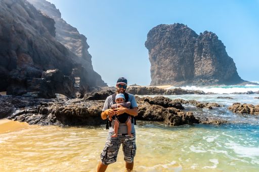 A young man and his baby on the Roque Del Moro in Cofete beach, Jandia natural park, Barlovento, south of Fuerteventura, Canary Island, Spain