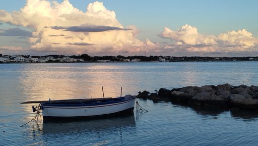Boat by the dock at dusk with beautiful clouds in the background