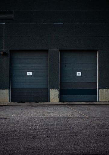 A vertical shot of two garage doors attached to an industrial building
