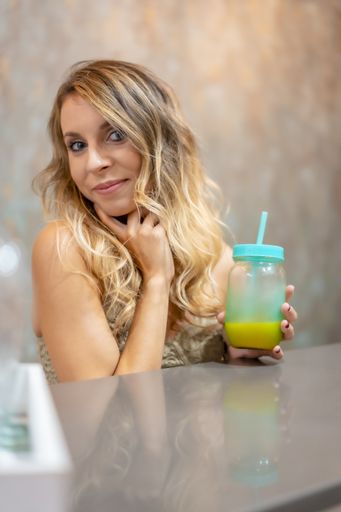 A young blonde girl posing with orange juice in her hands in San Sebastian, Gipuzkoa, Spain