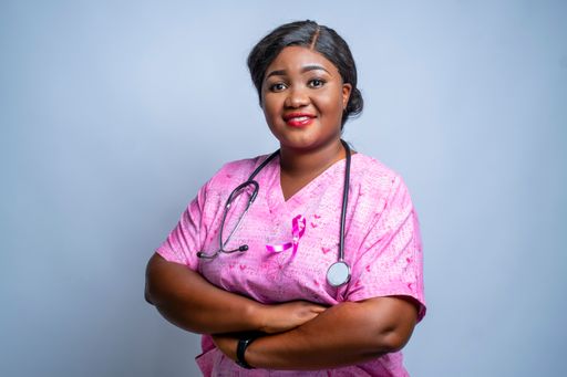 A portrait of a black female doctor with the breast cancer awareness symbol on her uniform